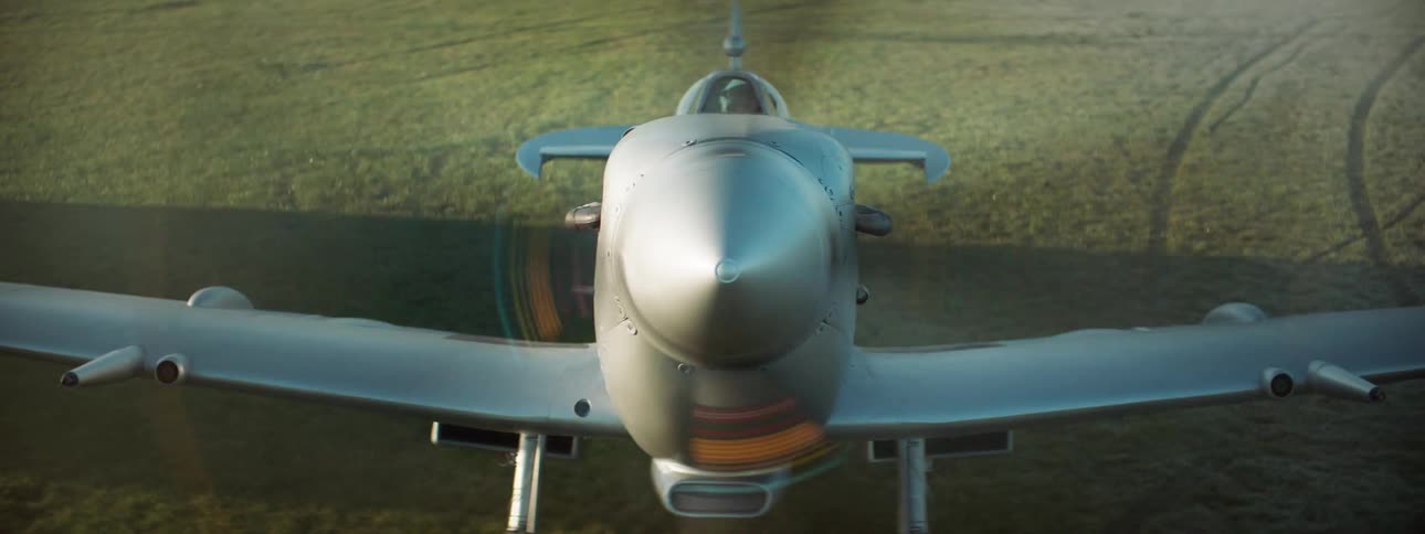 Singleengine plane parked on a lawn and its propeller starting to rotate releasing fire