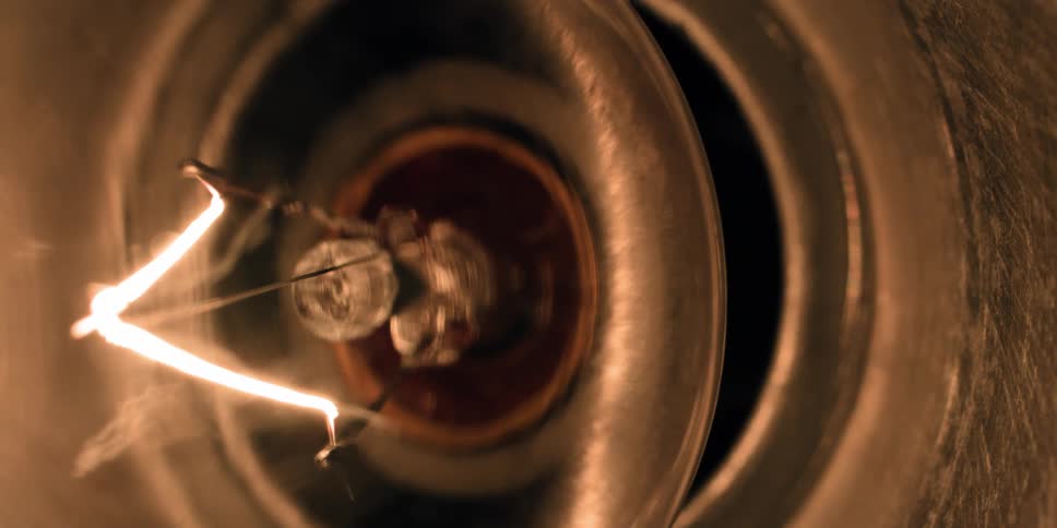 Extreme close up of a light bulb turning on and going off