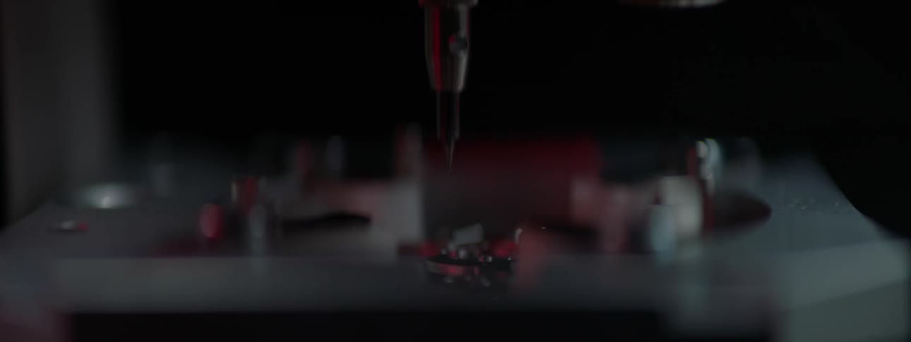 A machine with a needle moving up and down slowly