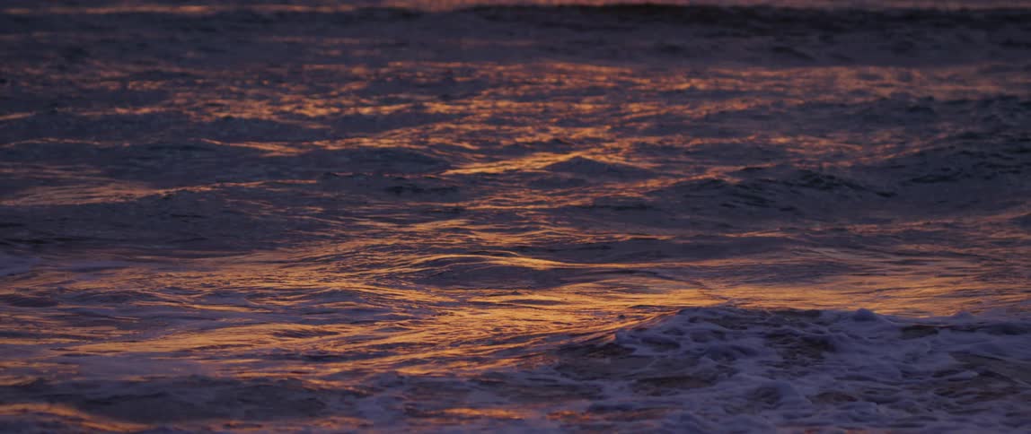Sea with calm waves and the solar reflection of the morning sky