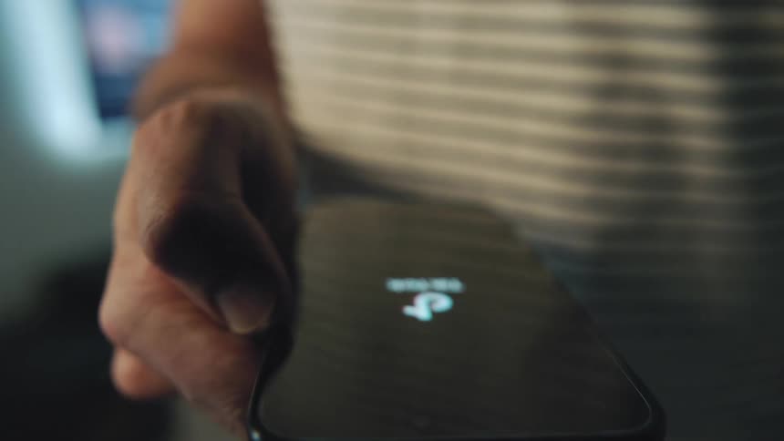 A male opens an app on his smartphone