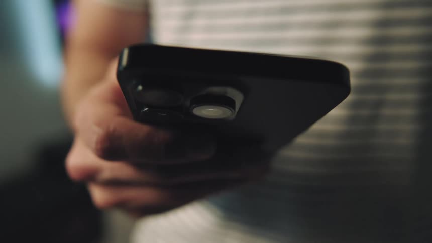 A male taps and swipes a smartphone