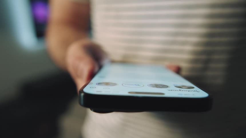A man taps an app on a smartphone