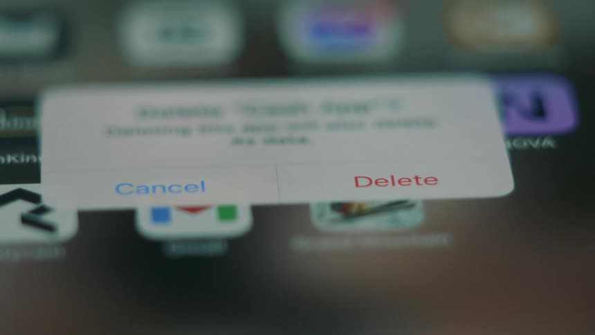 A person taps the phone screen deleting applications