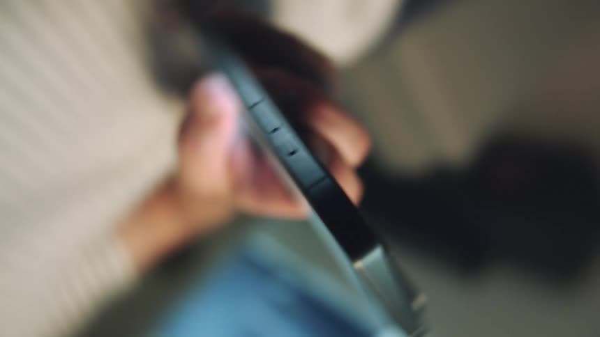 Spinning close up of a person holding a smartphone and texting