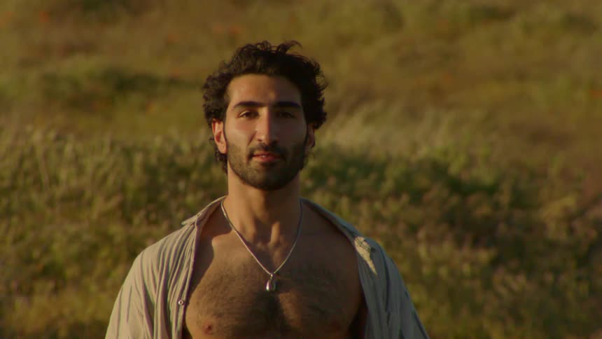 Man with open shirt and bare chest walking in nature