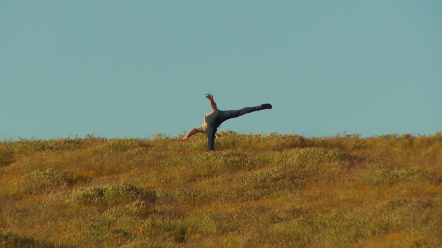 A man is dancing in the grass