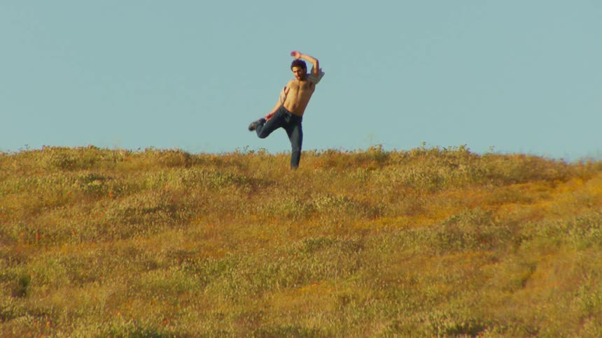 Man and a hill with grass jumping and dancing