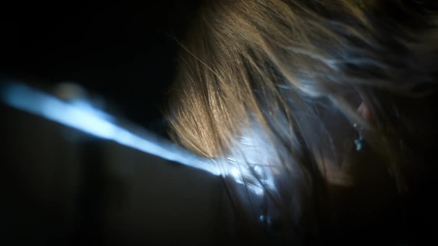 Side portrait of a girl looking through a box party and then opening it and a bright light emerging