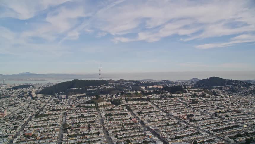 Aerial panorama of an urban city with mountains on the horizon on a blue sky day with clouds