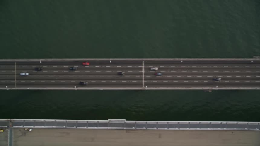 An aerial view of a bridge with eight lanes for cars and trucks