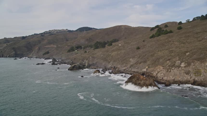 Aerial landscape of the sea hitting the rocky and mountainous coast