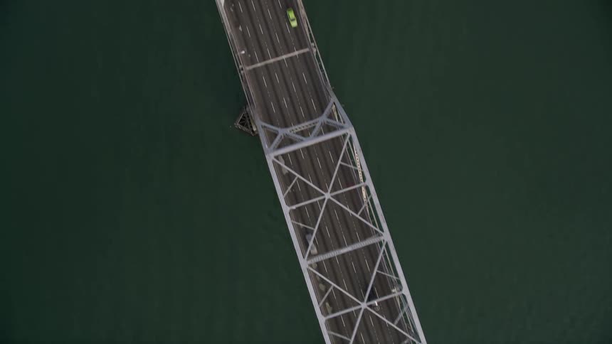 Cars cross a long bridge over water