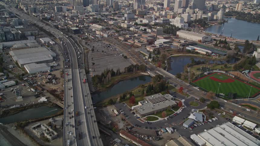 An aerial view of cars driving on a highway next to a city