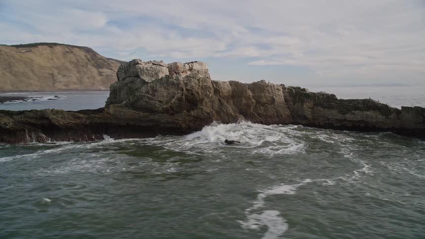 Aerial landscape of the sea with rocks and hillside on a cloudy day