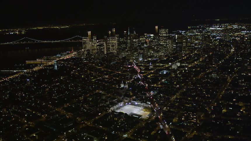 Aerial scene of a metropolis illuminated at night with skyscrapers and waterfront