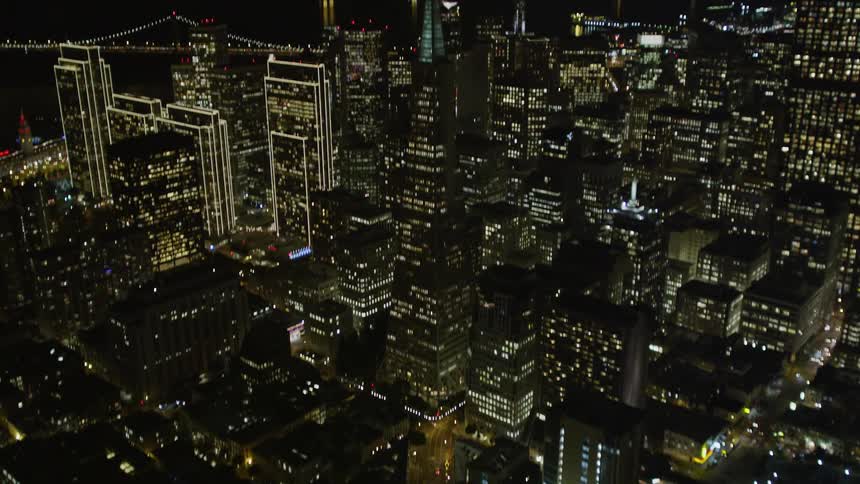 A view of a city at night with tall buildings in it
