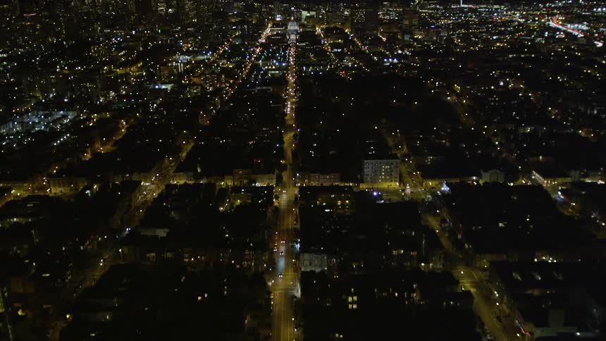 An aerial view of a city at night with several street lights on