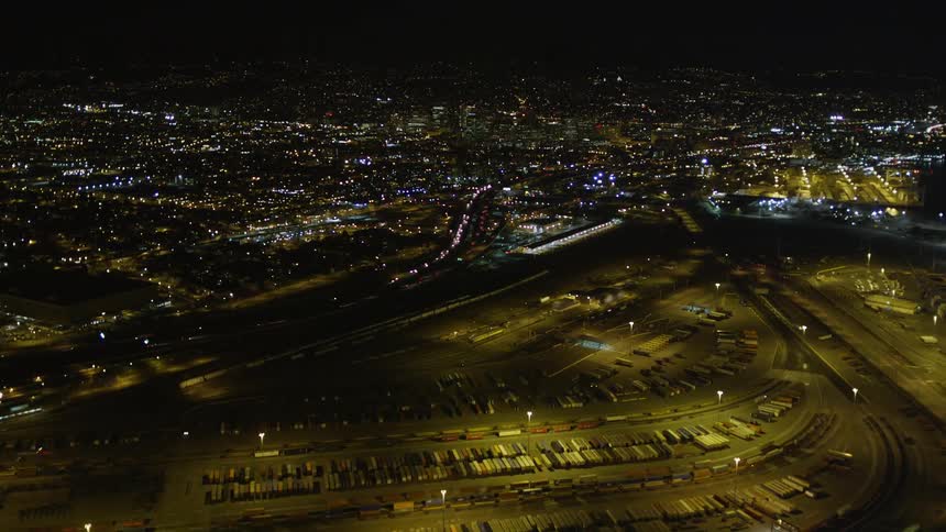 Aerial panorama of a logistics center and in the background a metropolis illuminated at night