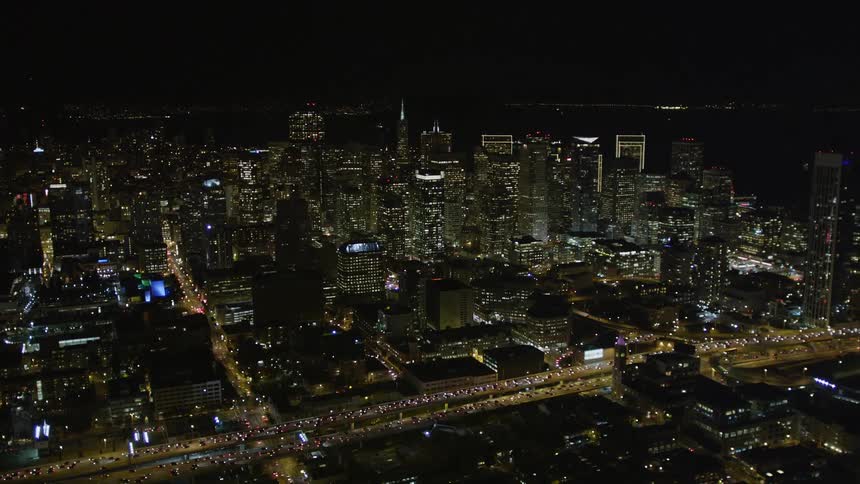 Aerial panorama of a metropolis illuminated at night with skyscrapers and intersections with vehicle traffic