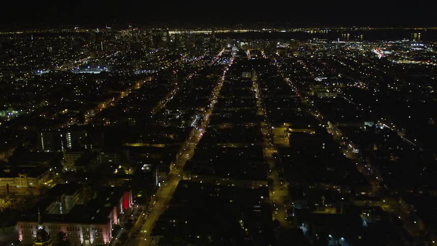 Aerial panorama of an illuminated urban city at night with skyscraper on the horizon