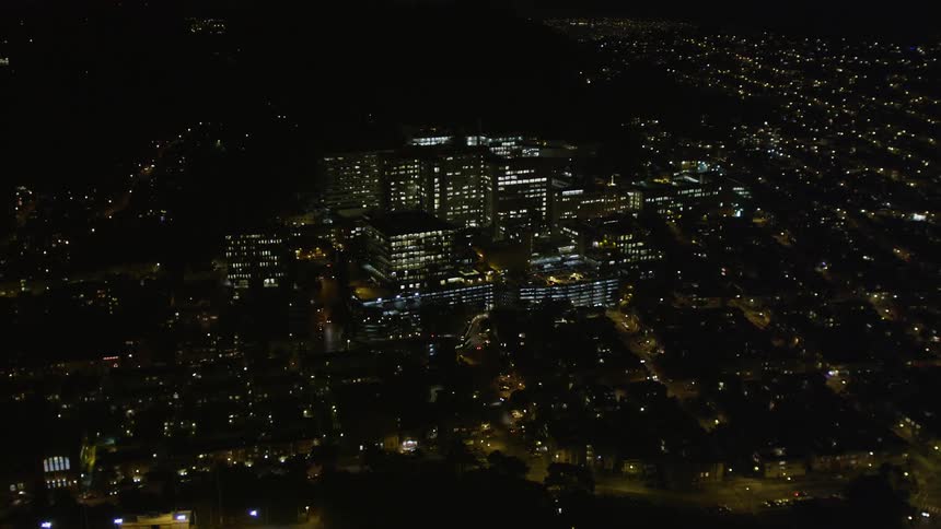 Aerial panorama of a stadium and urban and residential buildings in a metropolis at night