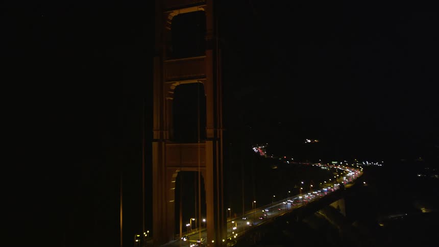 Aerial scene of a long bridge under the sea with vehicle traffic and night lighting