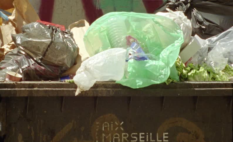 Garbage bags next to a wall in the city outdoors