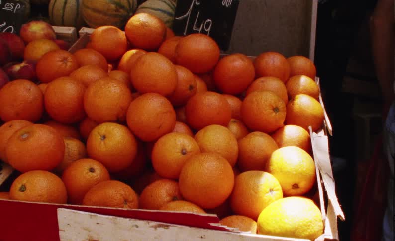 Closeup on a box with fresh oranges in a grocery store