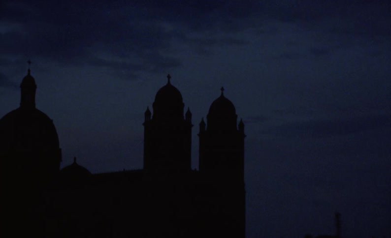 Exterior architecture with a view of the silhouette of an ancient cathedral at night