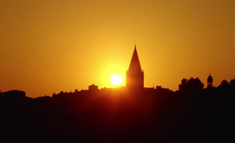 Red sunrise reflecting on the silhouette of a cathedral