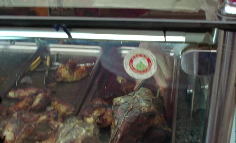 A person picking up a fried animal head with a utensil
