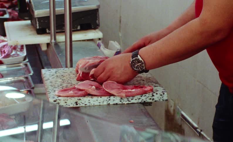 The butcher is cutting up a piece of meat