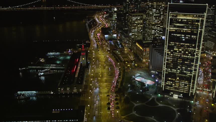 Traffic flows over the bridge into the city at night