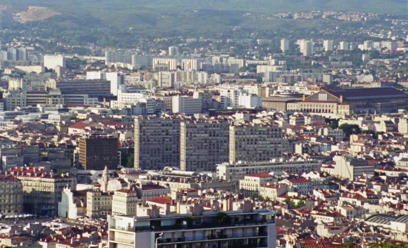 Panorama of an urban city with residential buildings and houses and mountains and hills on the horizon