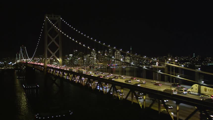 A huge bridge suspended in the water with a large highway of cars passing in both directions