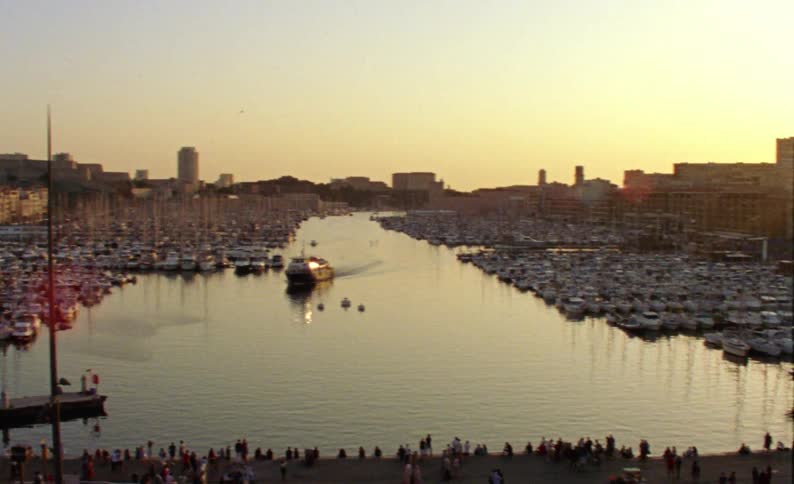 Old urban buildings around a sea canal with boats and yachts and the sunset on the horizon