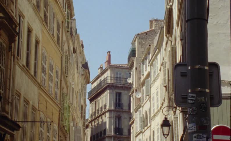 Street of an urban city with residential buildings on a cloudless blue sky day
