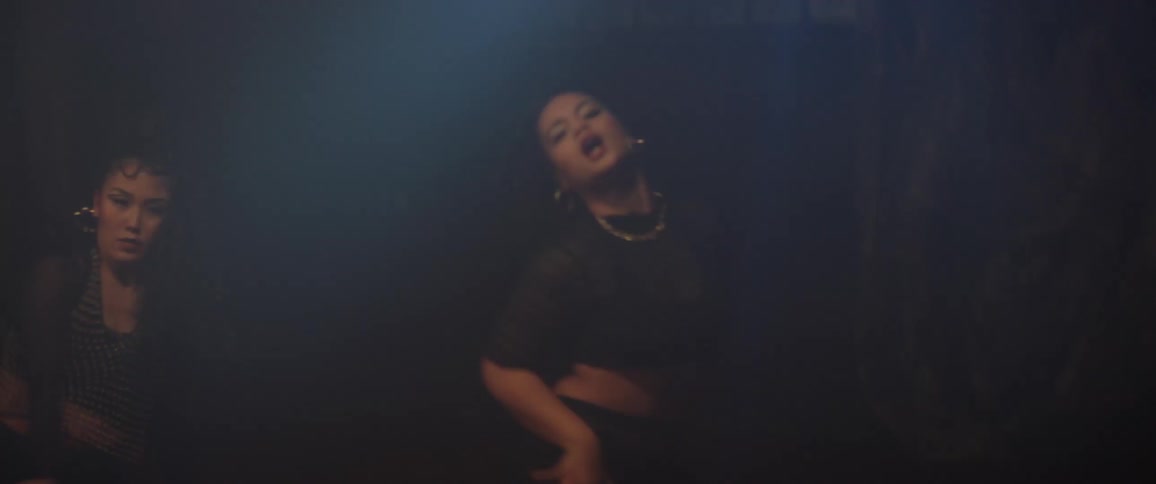 Two women indoors dancing a choreography in pairs