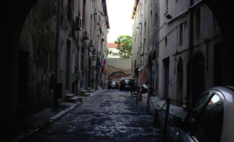 Suburban alley with parked cars during the day