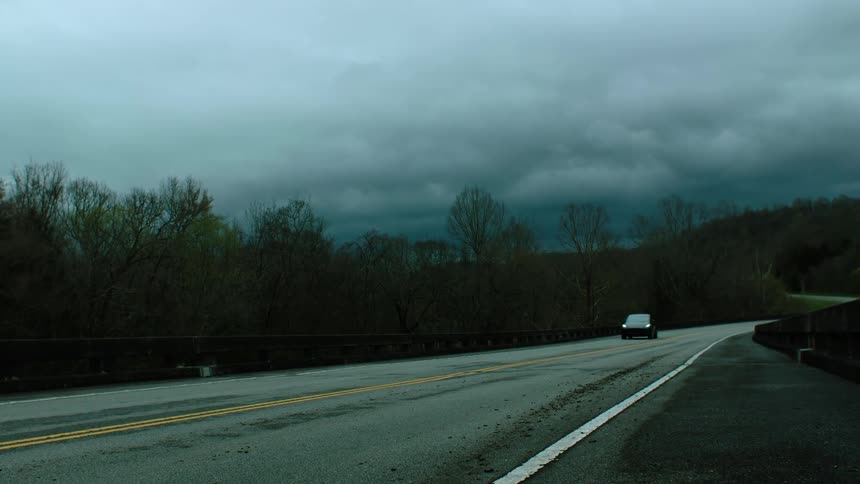 The car drives down the long highway