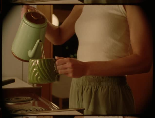 Portrait of a young woman pouring hot water into a cup of tea