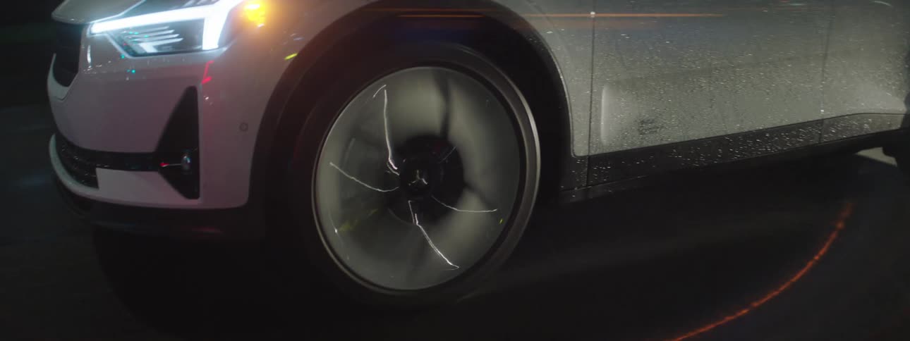 Closeup of the wheel and front of the vehicle moving along the road at night