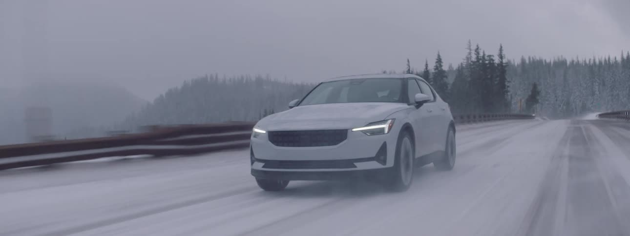 A car drives down a road in the winter