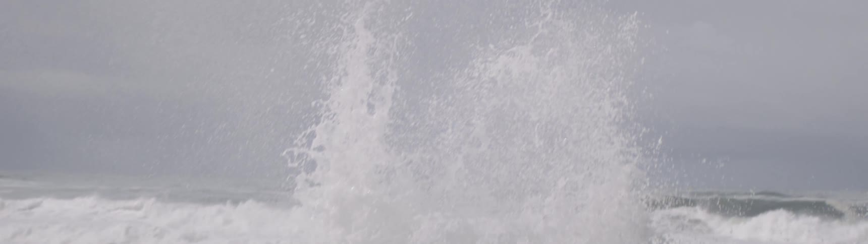 Ocean waves crashing strongly against the rocks and spreading upward