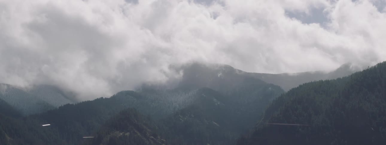 Landscape of mountain ranges and greenish forests and a blue sky day with clouds