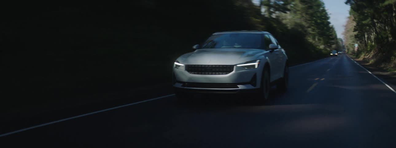 The car drives on the highway in the woods