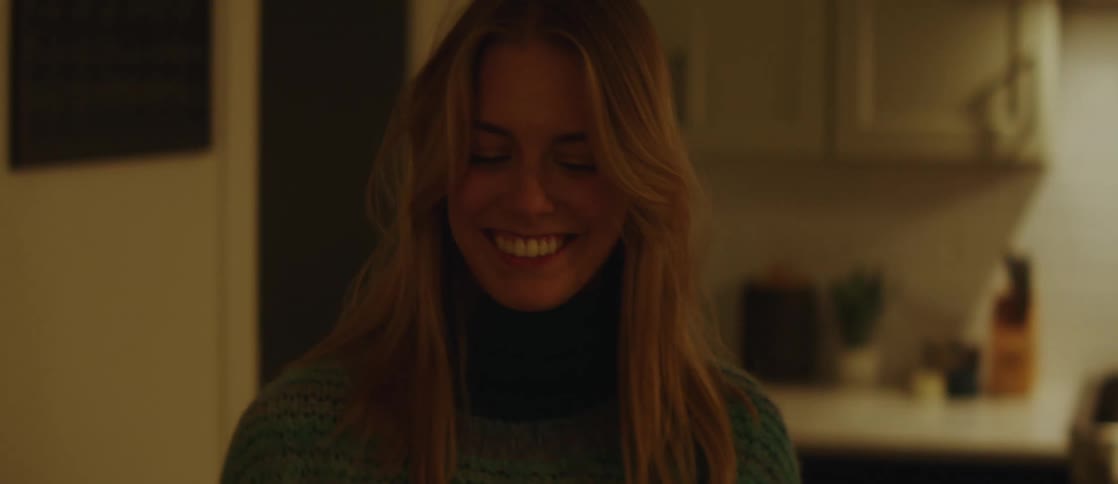 A young happy woman talks while cooking in the kitchen