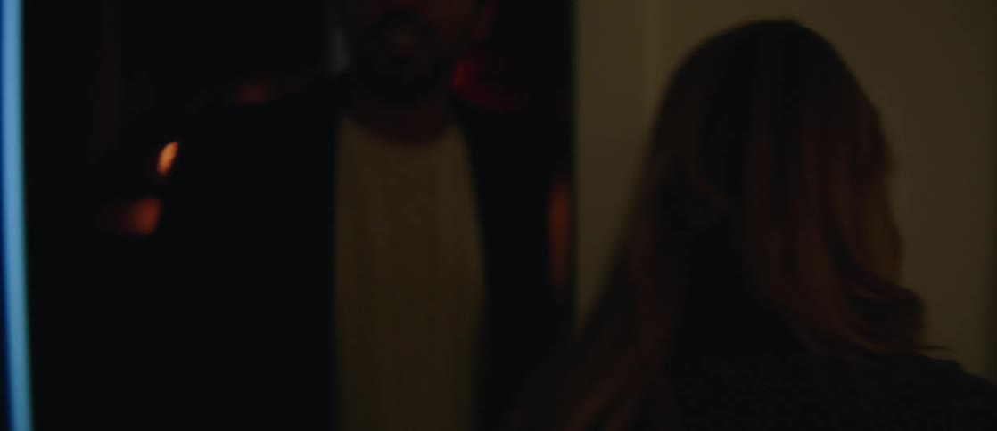 A young couple enters an apartment at night