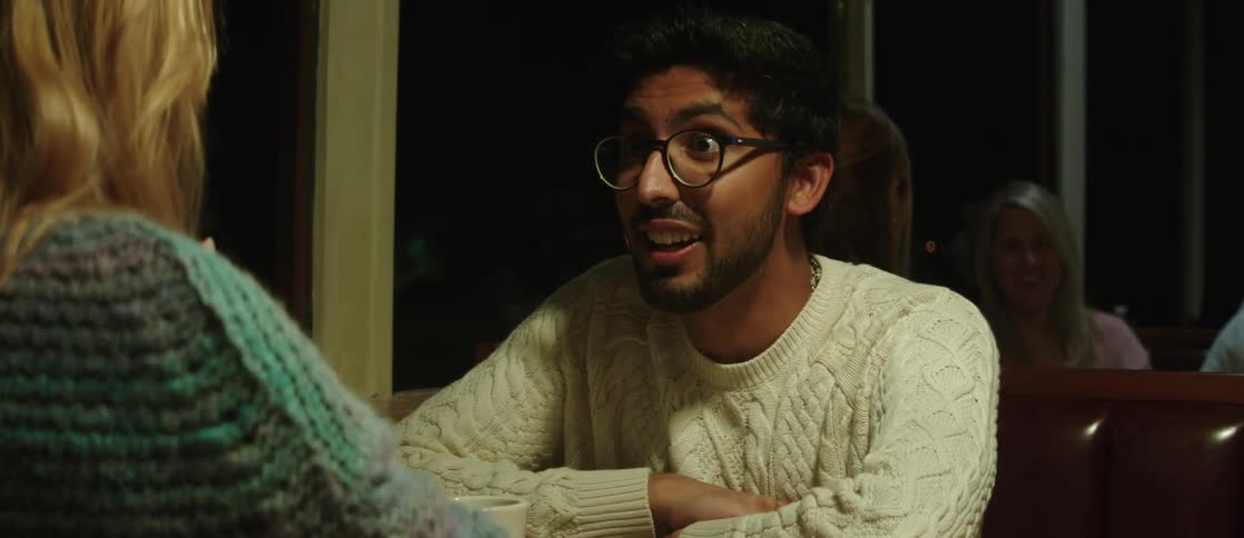 Portrait of a man sitting at the table talking and smiling with a woman in a restaurant at night